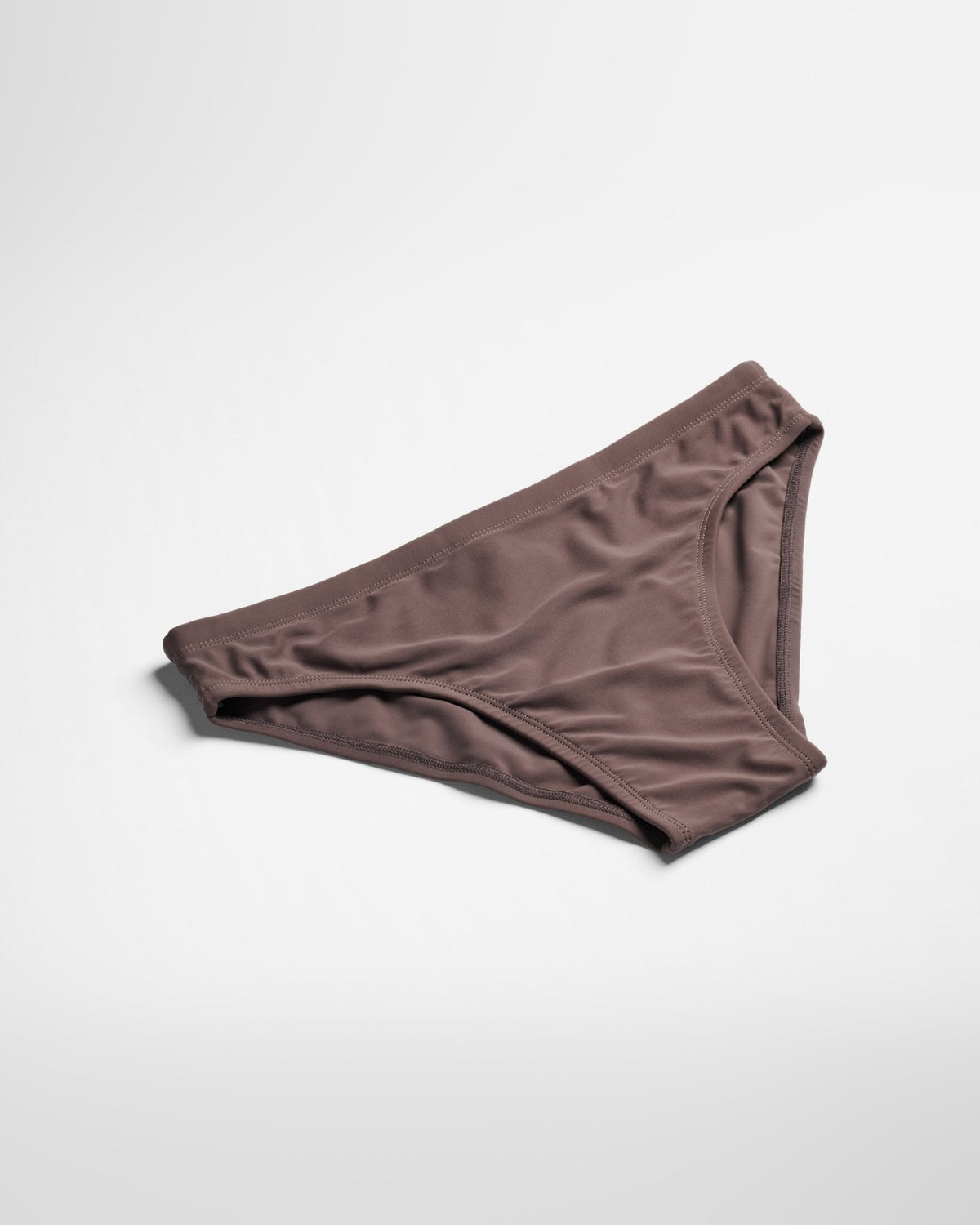 A brown swim brief shot from top down in a studio setting