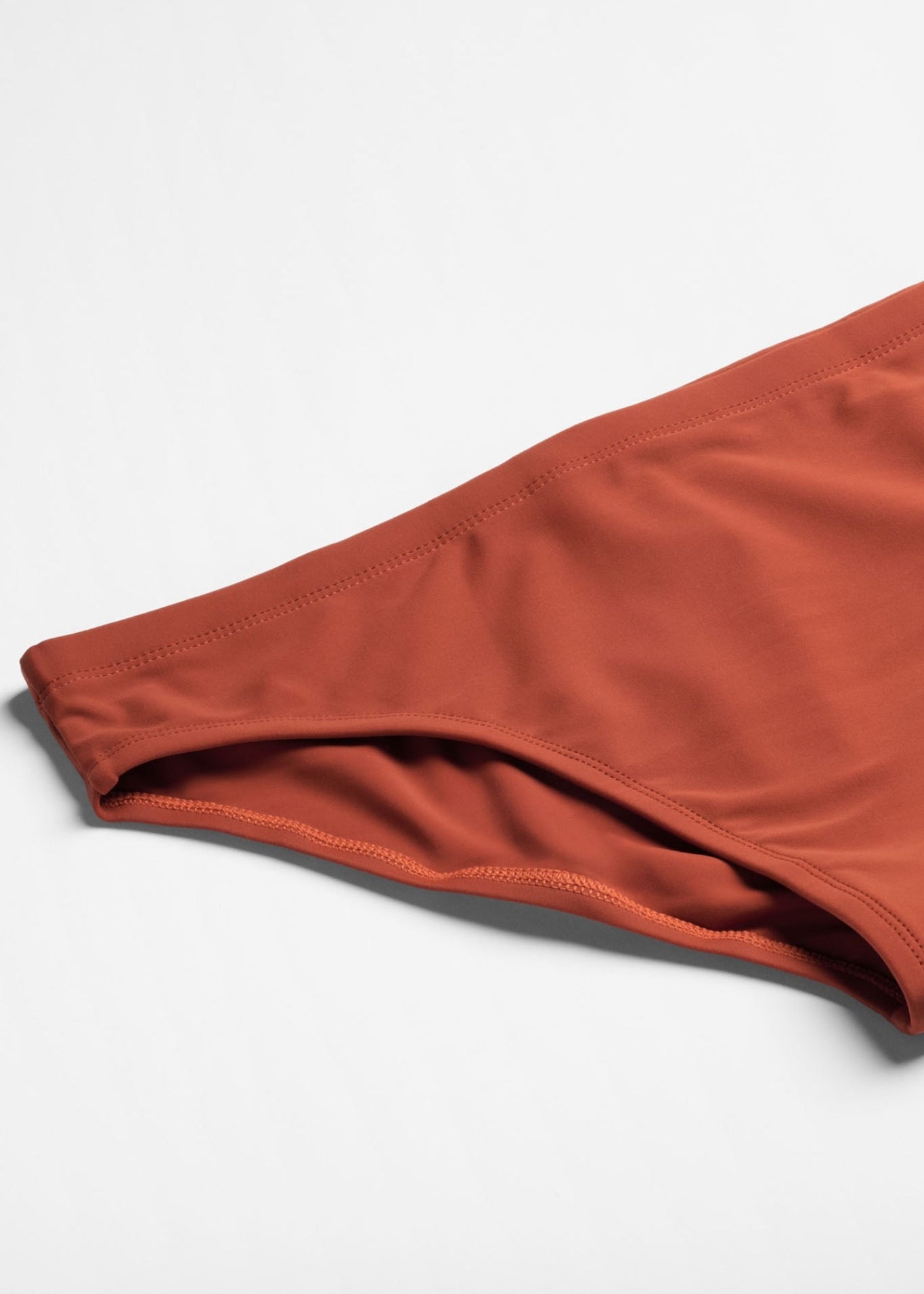 Close-up of red swim briefs on a light gray background