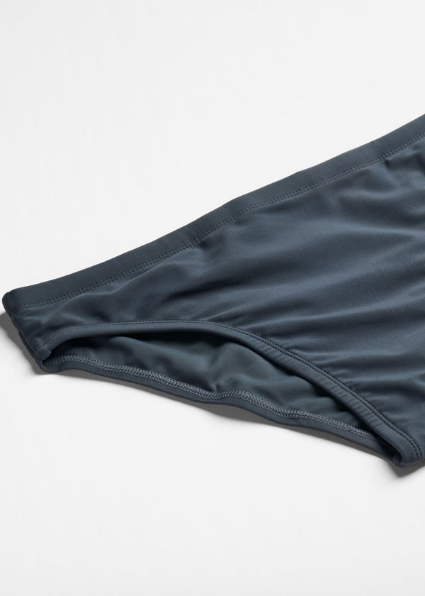 Dark blue swim briefs on a light gray background