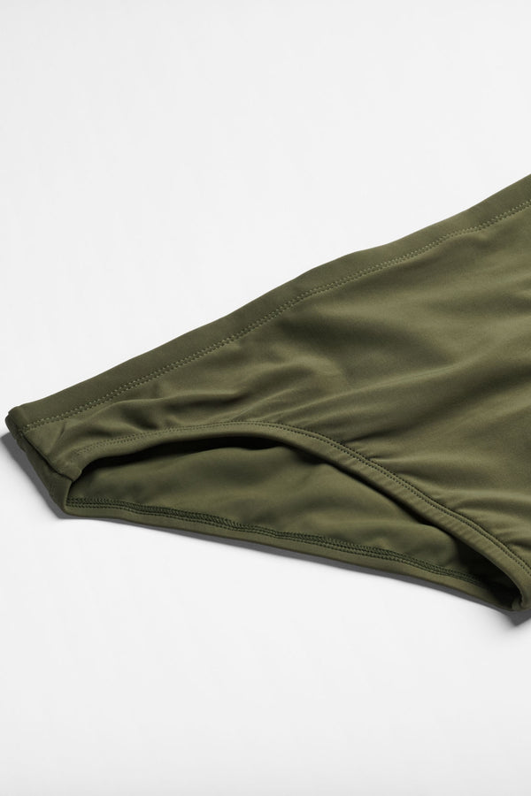 Green swim brief on a light gray background